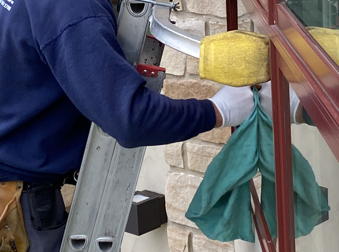 window washer on the ladder cleaning residential windows