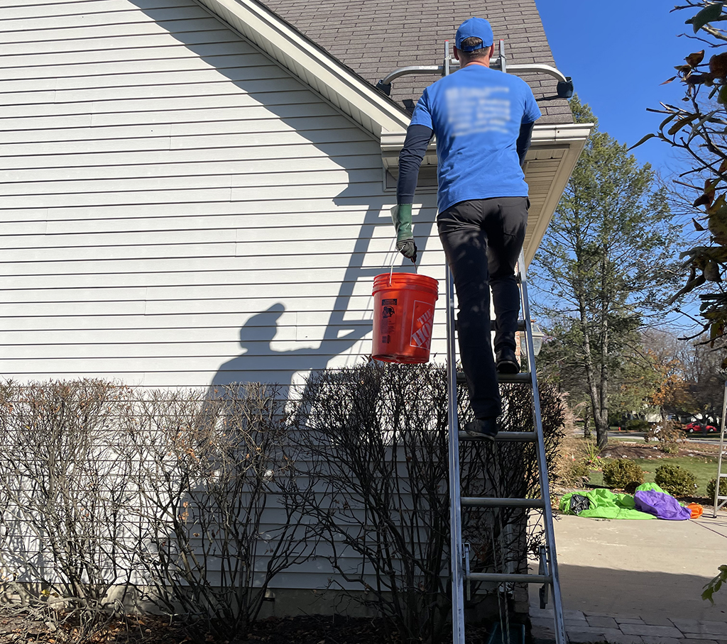 man on the ladder cleaning house gutters