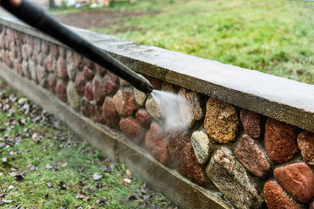 stone wall being power washed 